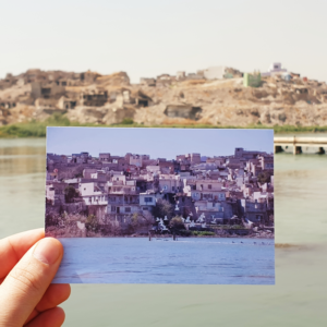 Image showing old postcard of old mosul in the foreground with ruins of destroyed old mosul in the background
